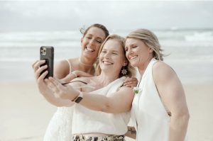 Heidi Robertson, celebrant and MC, grabbing a selfie with newlyweds Erin and Courtney