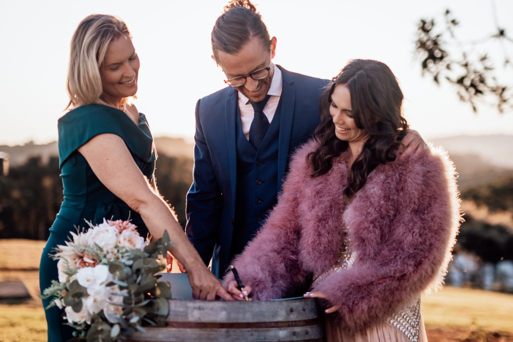 Celebrant Heidi Robertson showing newlyweds where to sign