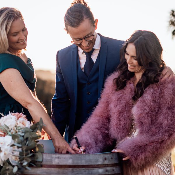 Celebrant Heidi Robertson showing newlyweds where to sign
